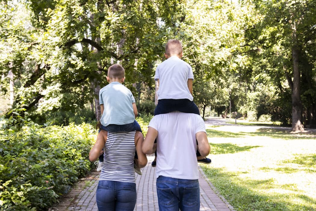 Foto de una familia en el campo con los hijos cogidos en sus hombros